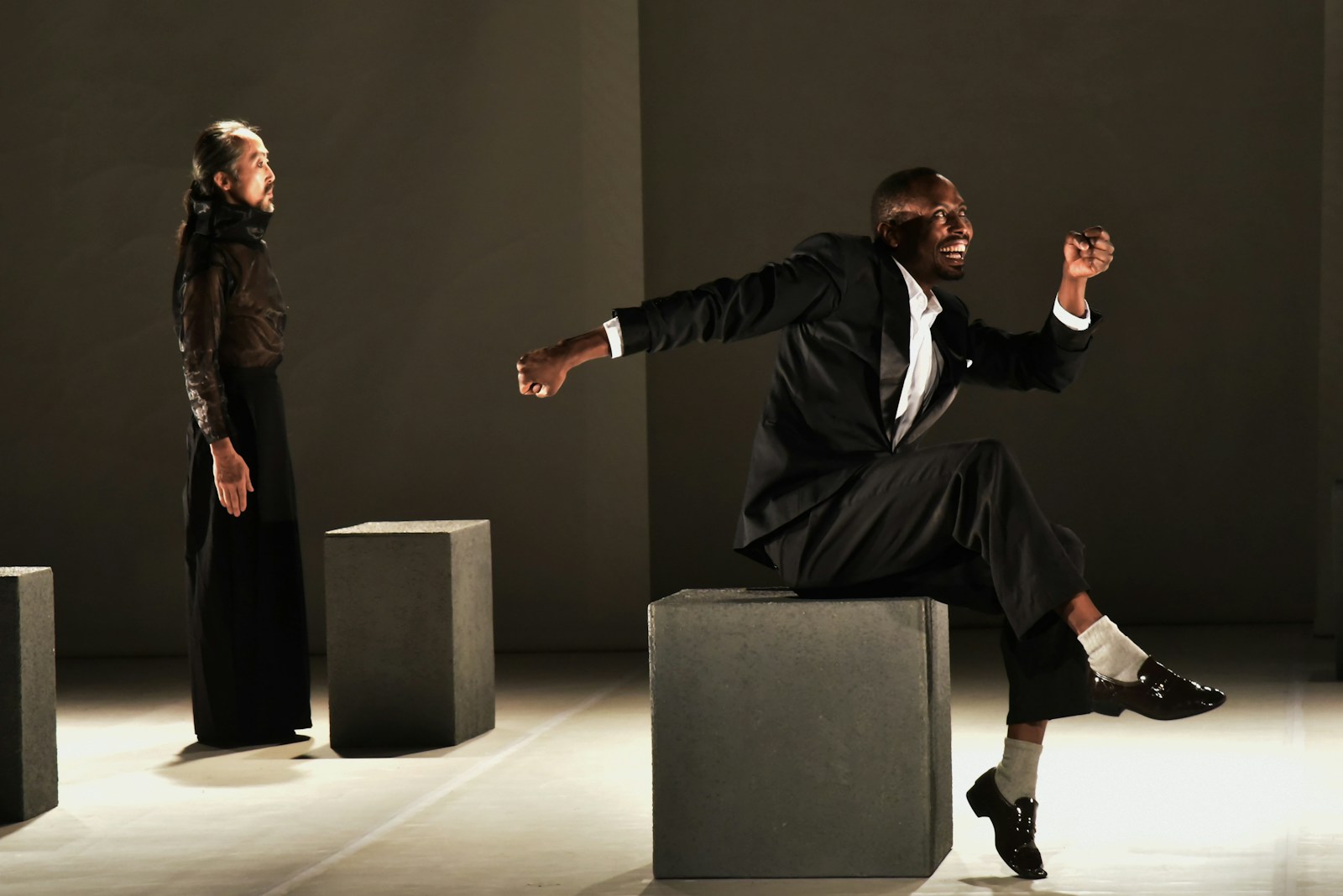 man in black suit sitting on gray chair